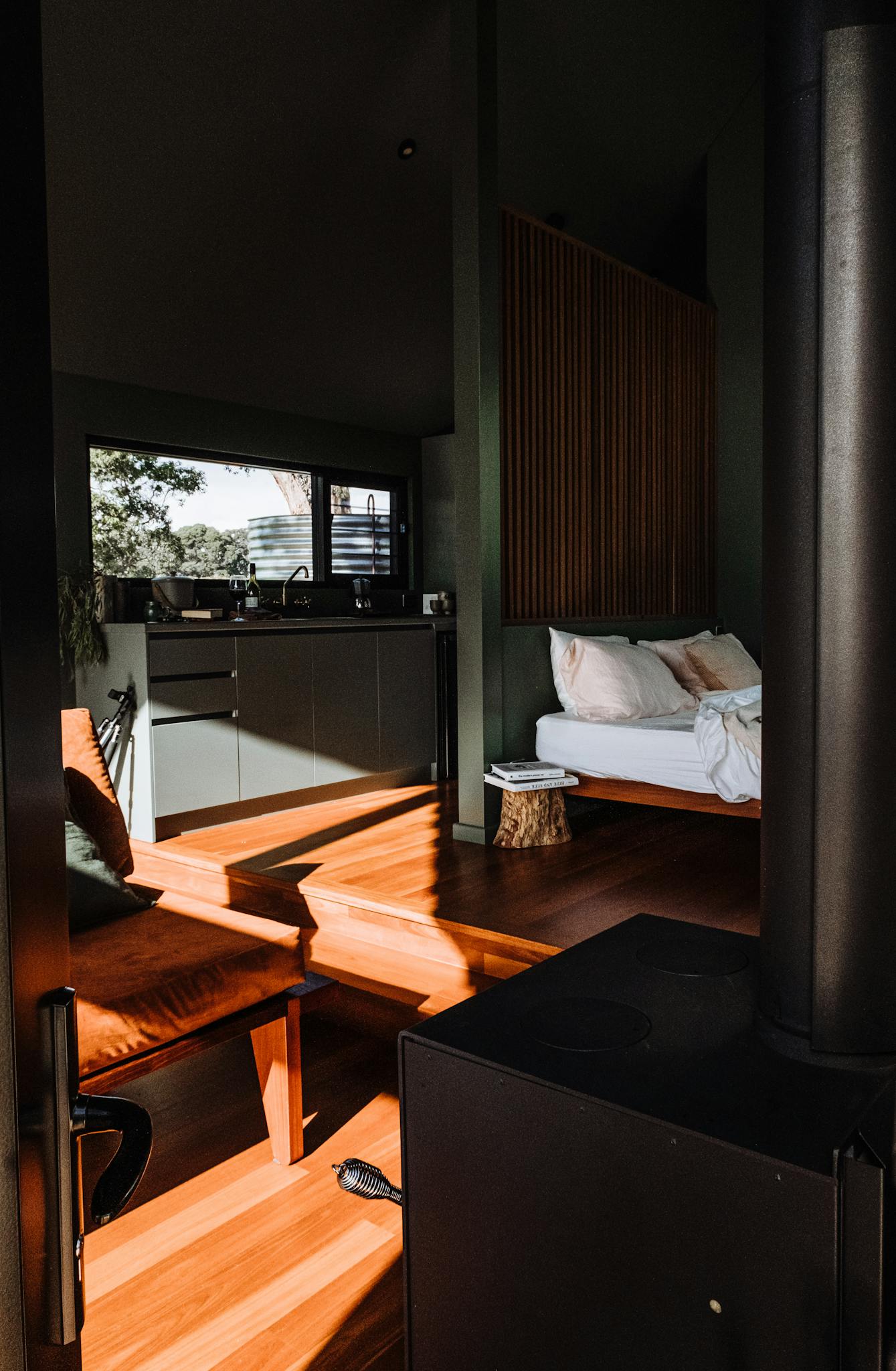 Contemporary room featuring a stylish bed and warm sunlight permeating through modern decor.